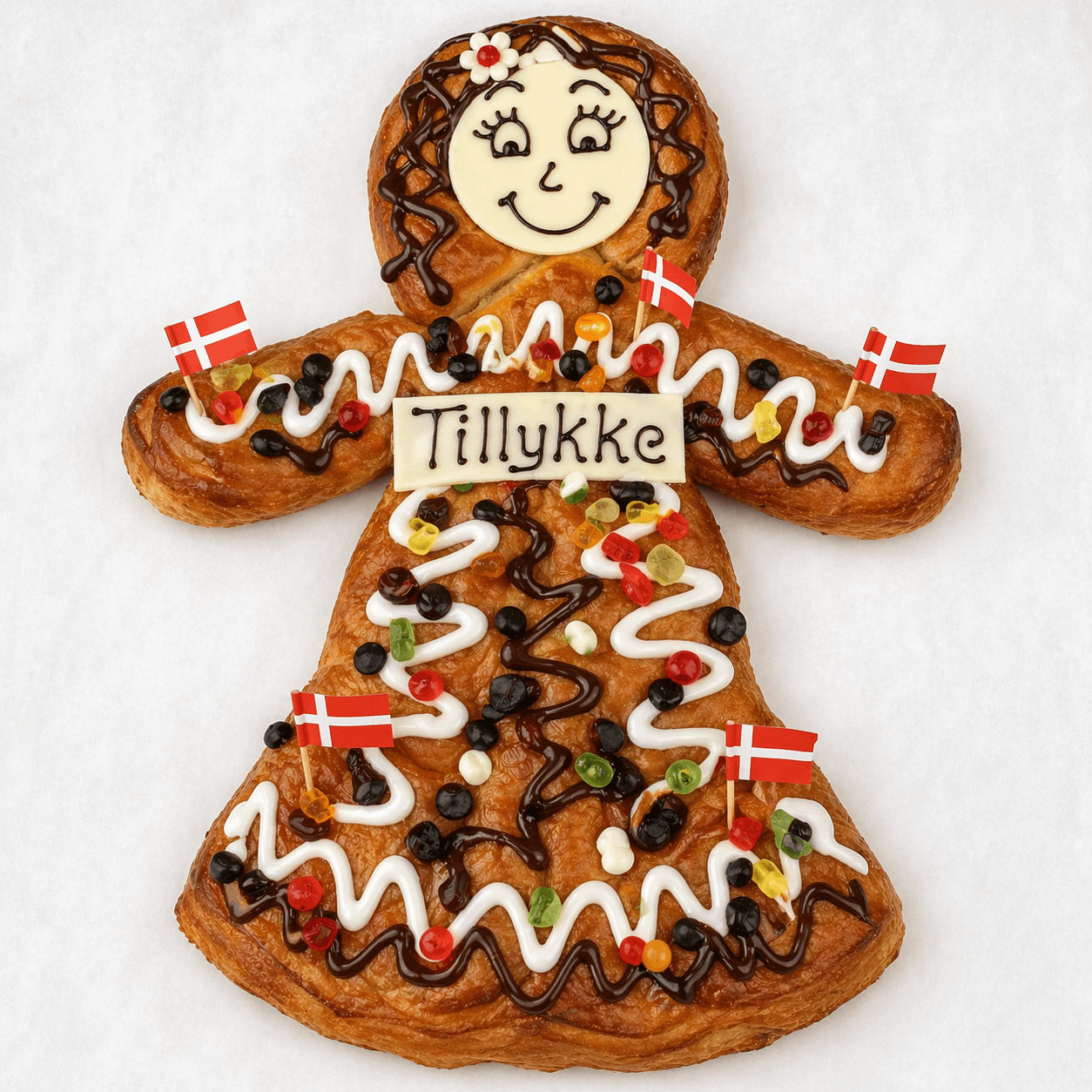 Kagekassens klassiske kagekone med Tillykke-skilt og dansk pynt